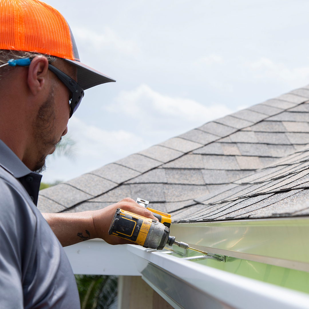 Taylor's Roofing employee installing gutter